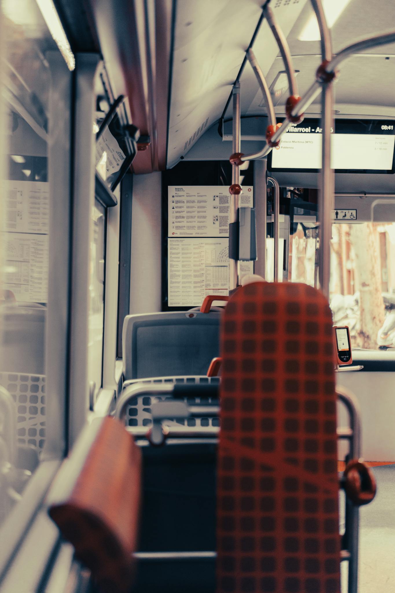 Empty city bus interior with seats and windows in view, offering a modern public transport concept.